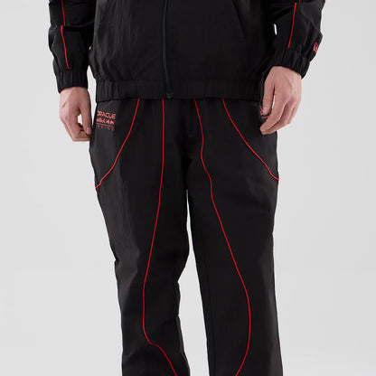 The model is wearing these Red Bull Racing Piping Track Pants in black. 4