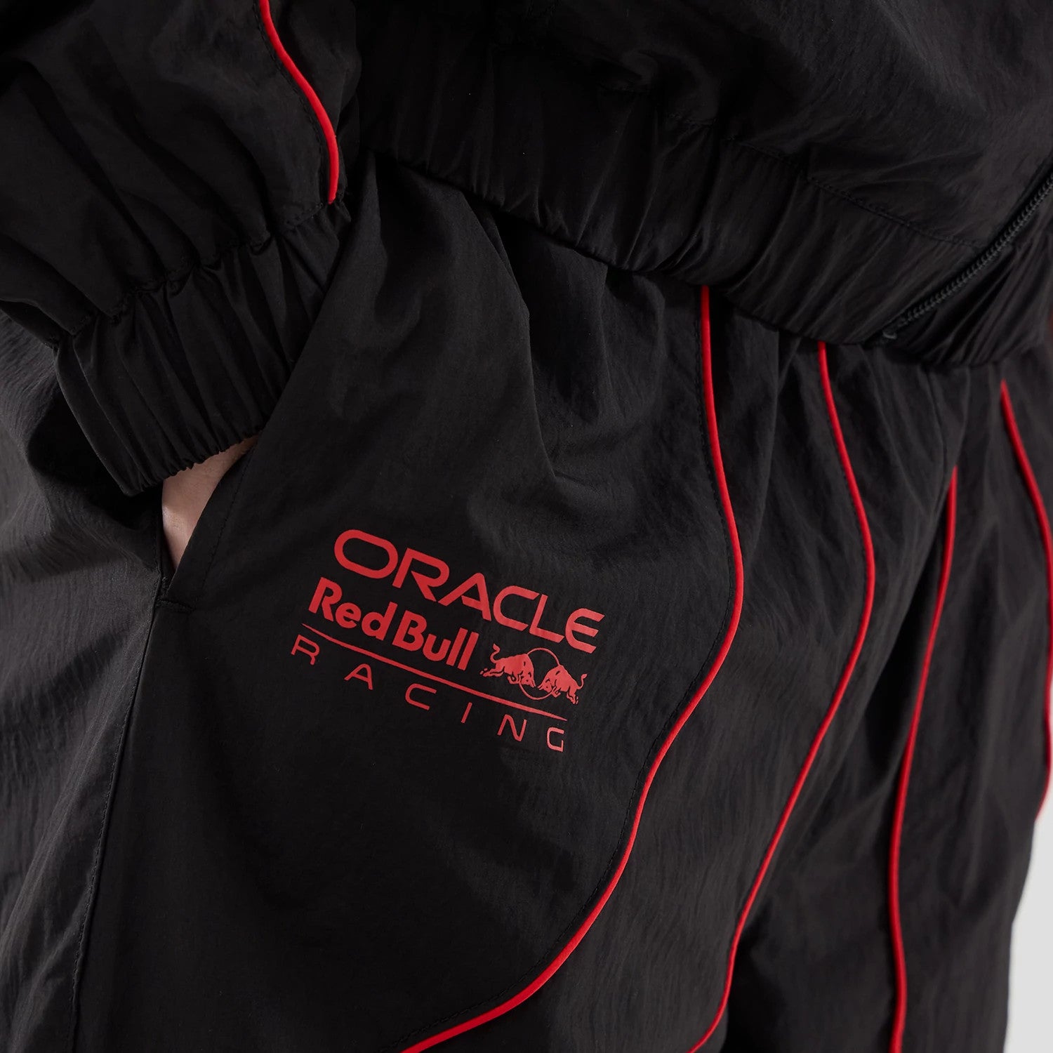 The model is wearing these Red Bull Racing Piping Track Pants in black. 5