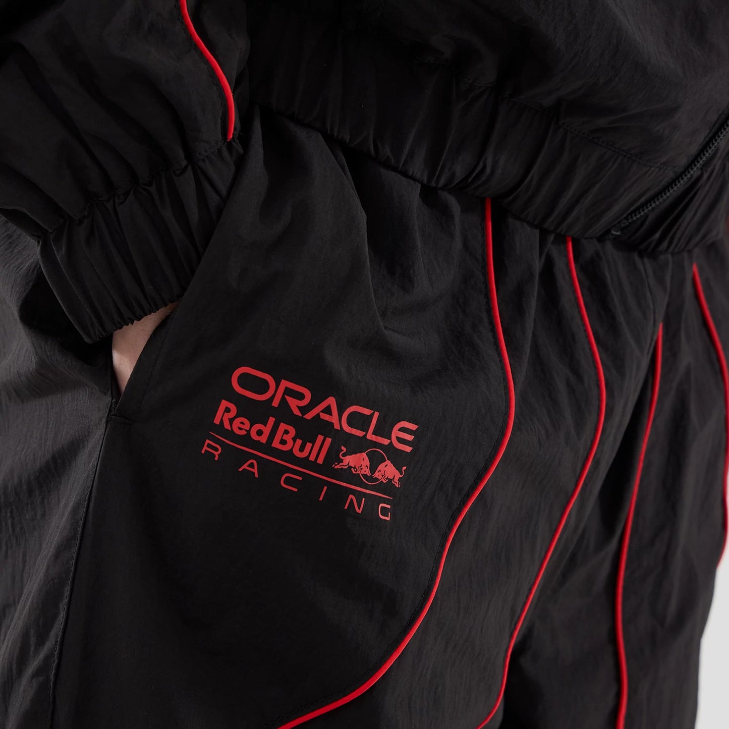 The model is wearing these Red Bull Racing Piping Track Pants in black. 5
