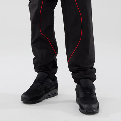 The model is wearing these Red Bull Racing Piping Track Pants in black. 7