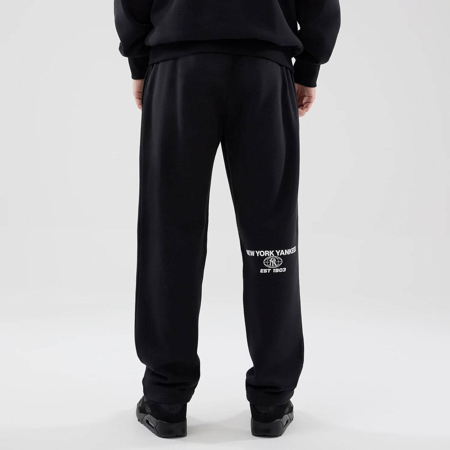The model is wearing these MLB Logo Graphic New York Yankees Straight Leg Joggers in black. 2