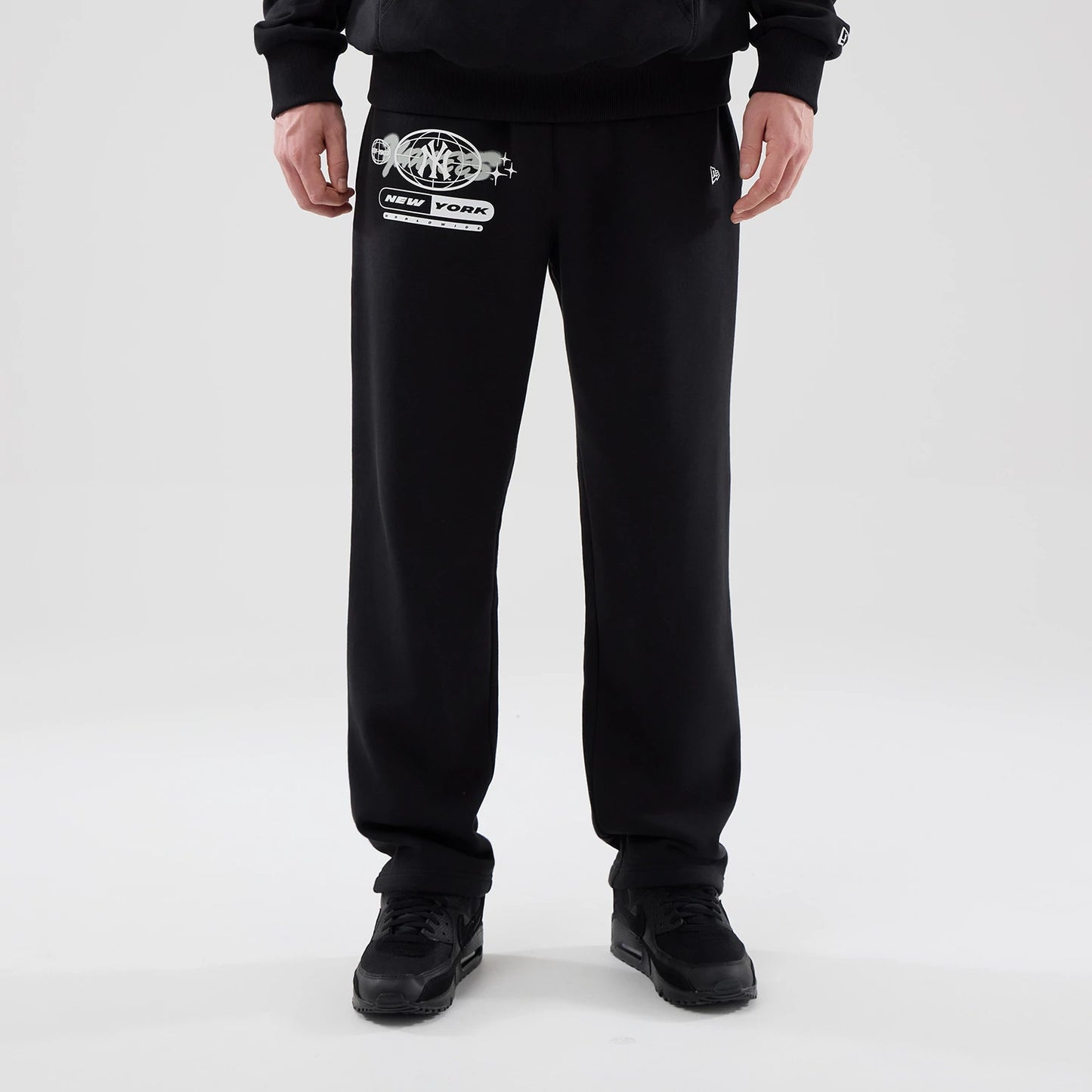 The model is wearing these MLB Logo Graphic New York Yankees Straight Leg Joggers in black. 1