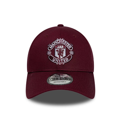 Manchester United FC Dark Red New Era 9FORTY Adjustable Cap, front view showing the detailed white and red embroidered club crest on the front panel, with a curved visor and a 9FORTY size sticker on the dark red visor.