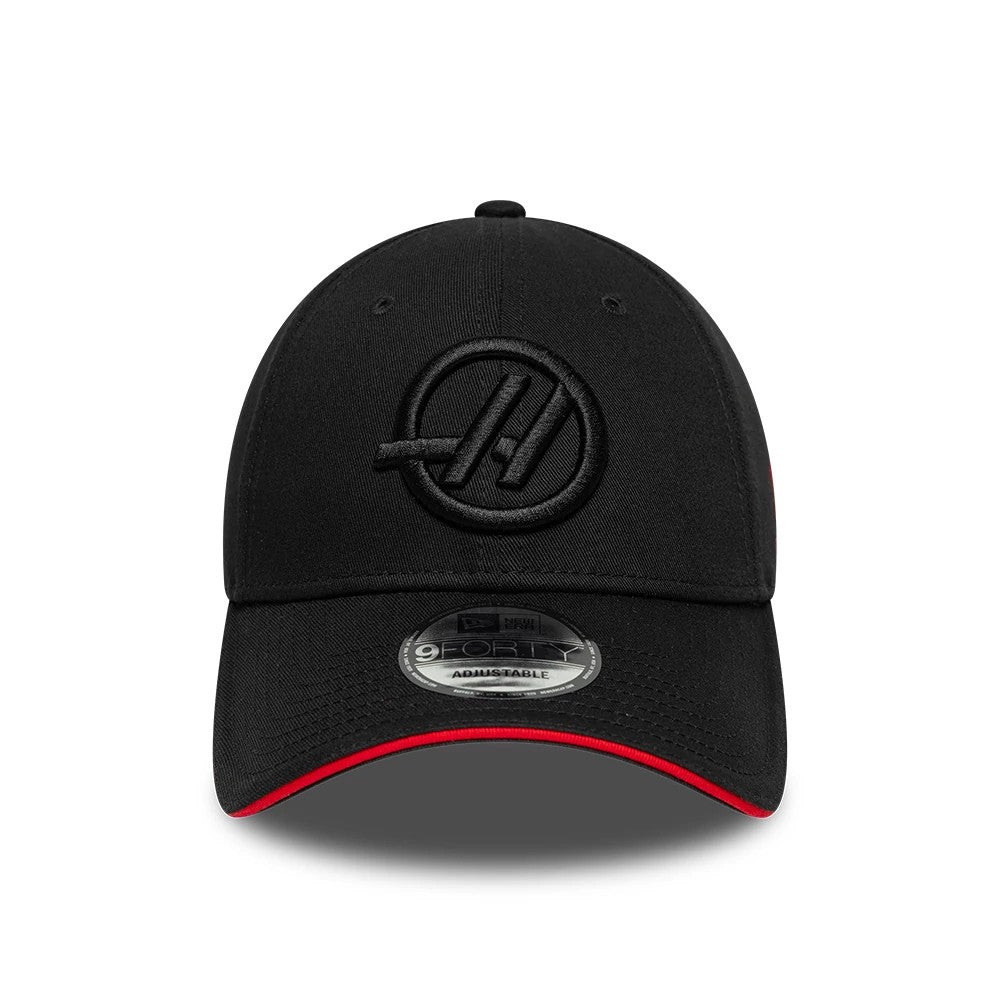 TGR Haas F1 Team Cotton Black New Era 9FORTY Adjustable Cap, front view showing the black raised embroidered Haas logo on the front panels, complemented by a curved black visor with a red edge and a 9FORTY size sticker on top.