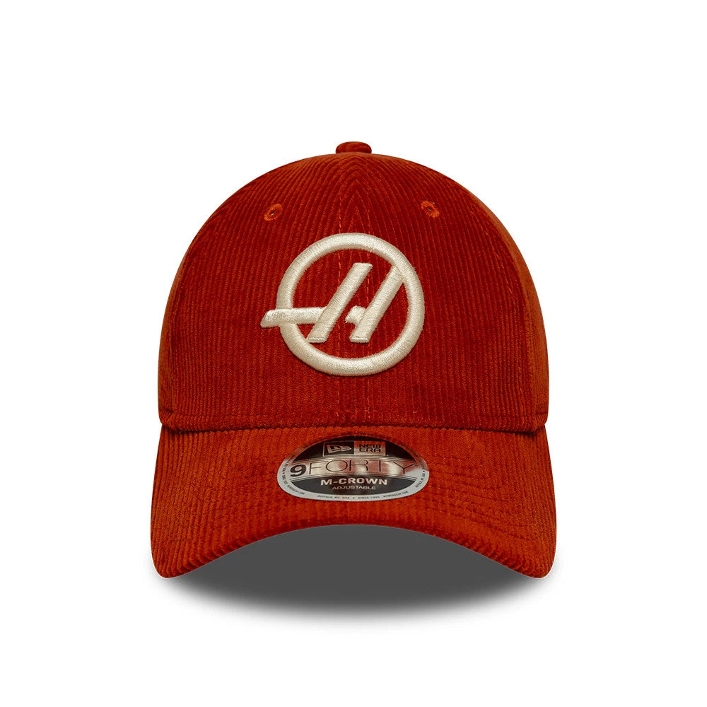 TGR Haas F1 Team Cord Red New Era 9FORTY M-Crown Adjustable Cap, front view showing a white circular embroidered logo on the structured red corduroy crown, matching red top button, and a 9FORTY size sticker on the curved visor.