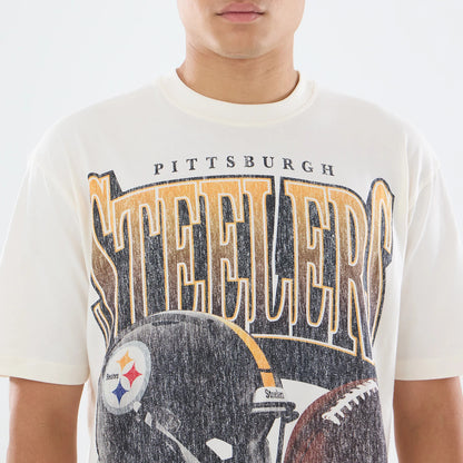 New Era Pittsburgh Steelers NFL Sport Classic Cream T-Shirt, front view on a model showing a printed design with large Steelers lettering across the chest, a detailed print of a football helmet with team logo beneath, and a faded vintage effect.