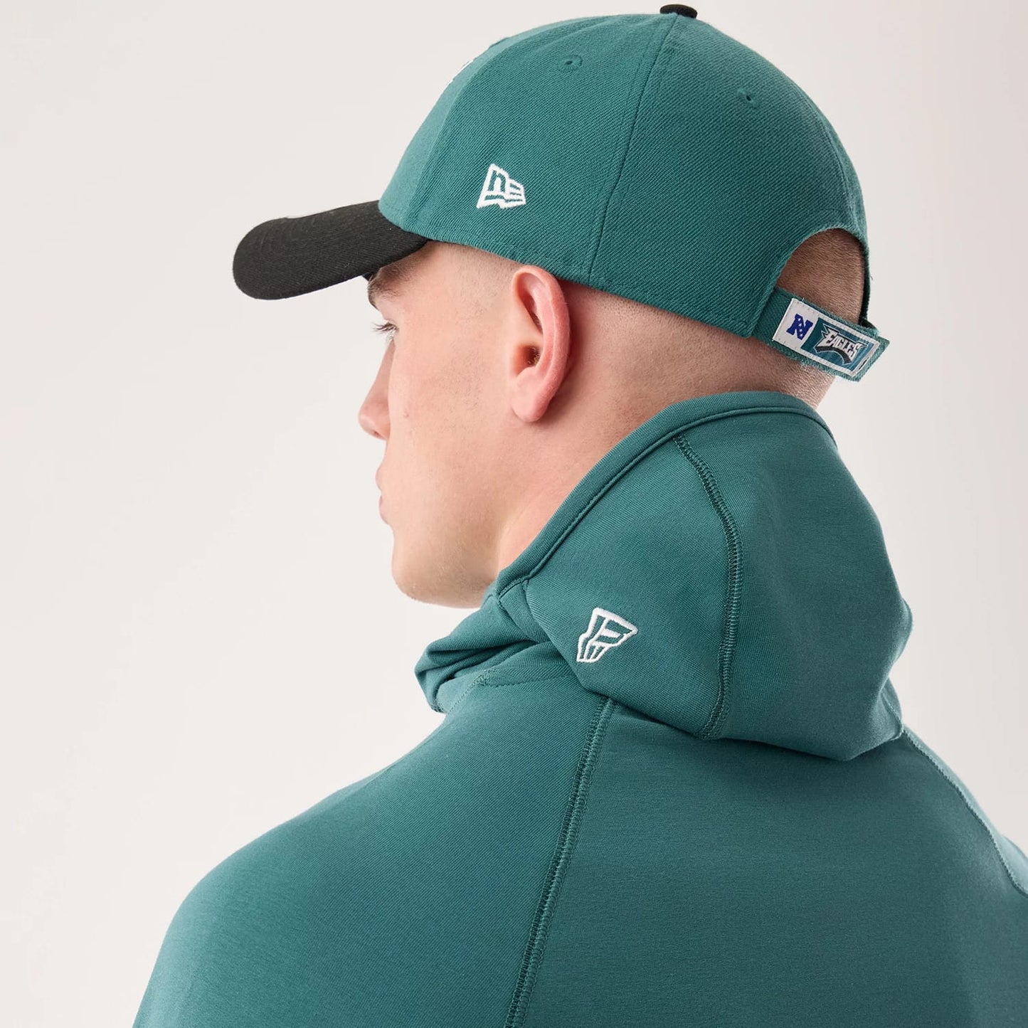 The model is wearing this NFL Sideline 2026 Philadelphia Eagles Balaclava Hoodie in dark green. 7