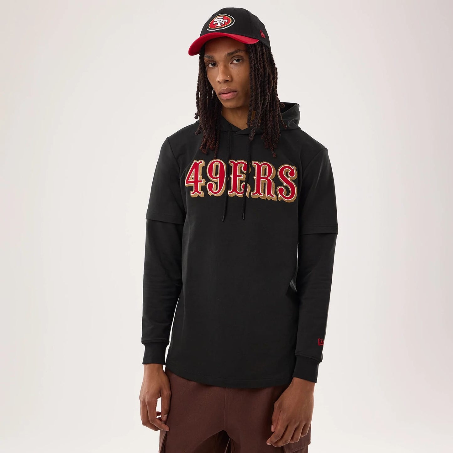 The model is wearing this NFL Sideline 2026 San Francisco 49ers Double Sleeve Hoodie in black. 1