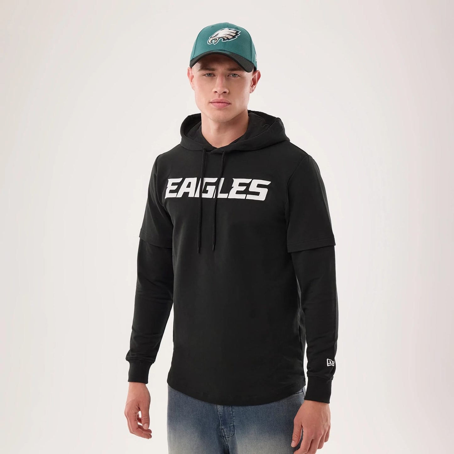 The model is wearing this NFL Sideline 2026 Philadelphia Eagles Double Sleeve Hoodie in black. 1