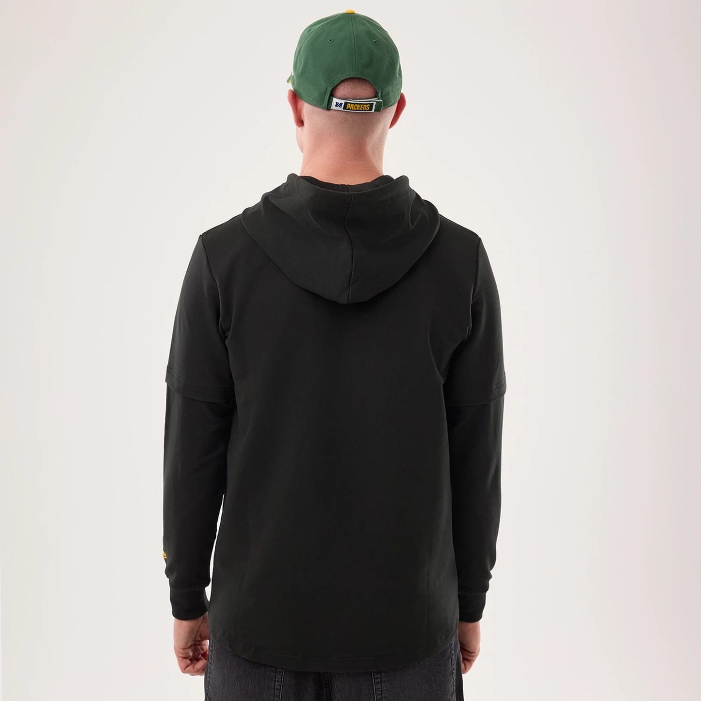 The model is wearing this NFL Sideline 2026 Green Bay Packers Double Sleeve Hoodie in black. 2