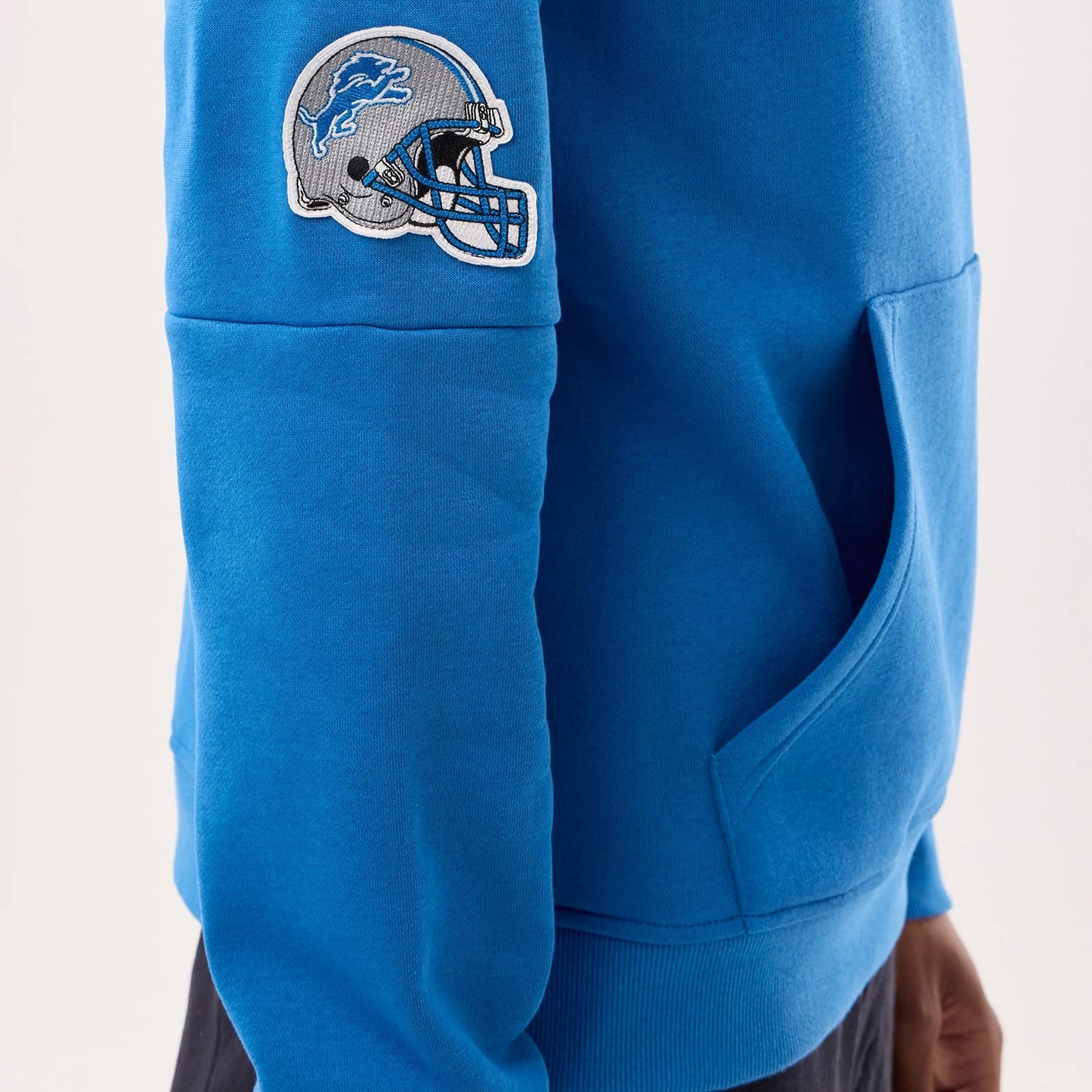 The model is wearing this NFL Sideline 2026 Detroit Lions Pullover Hoodie in blue. 5