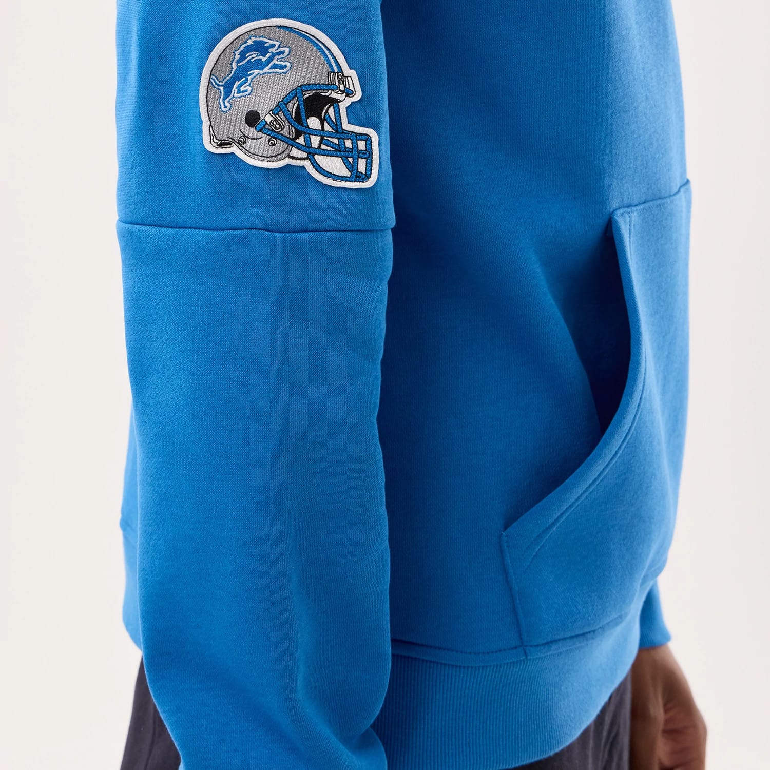 The model is wearing this NFL Sideline 2026 Detroit Lions Pullover Hoodie in blue. 5