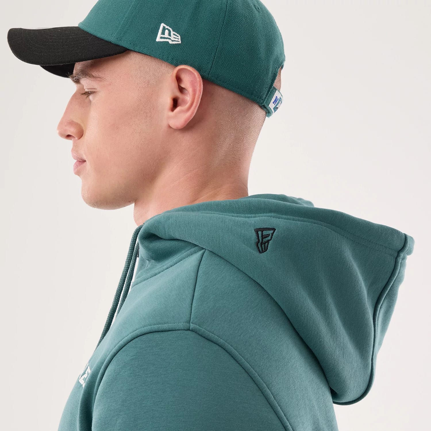 The model is wearing this NFL Sideline 2026 Philadelphia Eagles Pullover Hoodie in dark green. 5