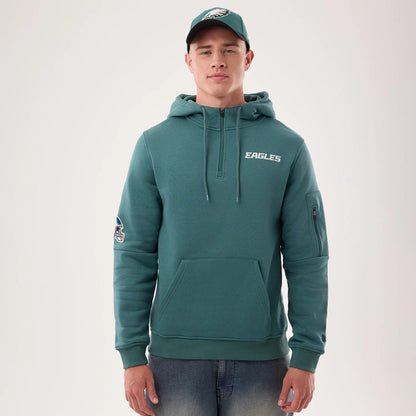 The model is wearing this NFL Sideline 2026 Philadelphia Eagles Pullover Hoodie in dark green. 1