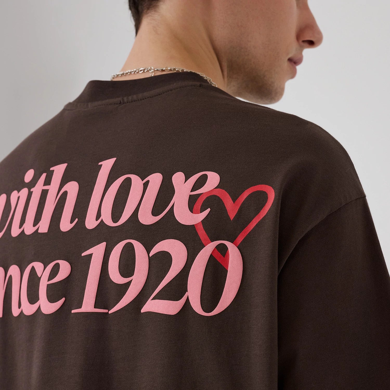The model is wearing this New Era Love Graphic T-Shirt in dark brown. 3