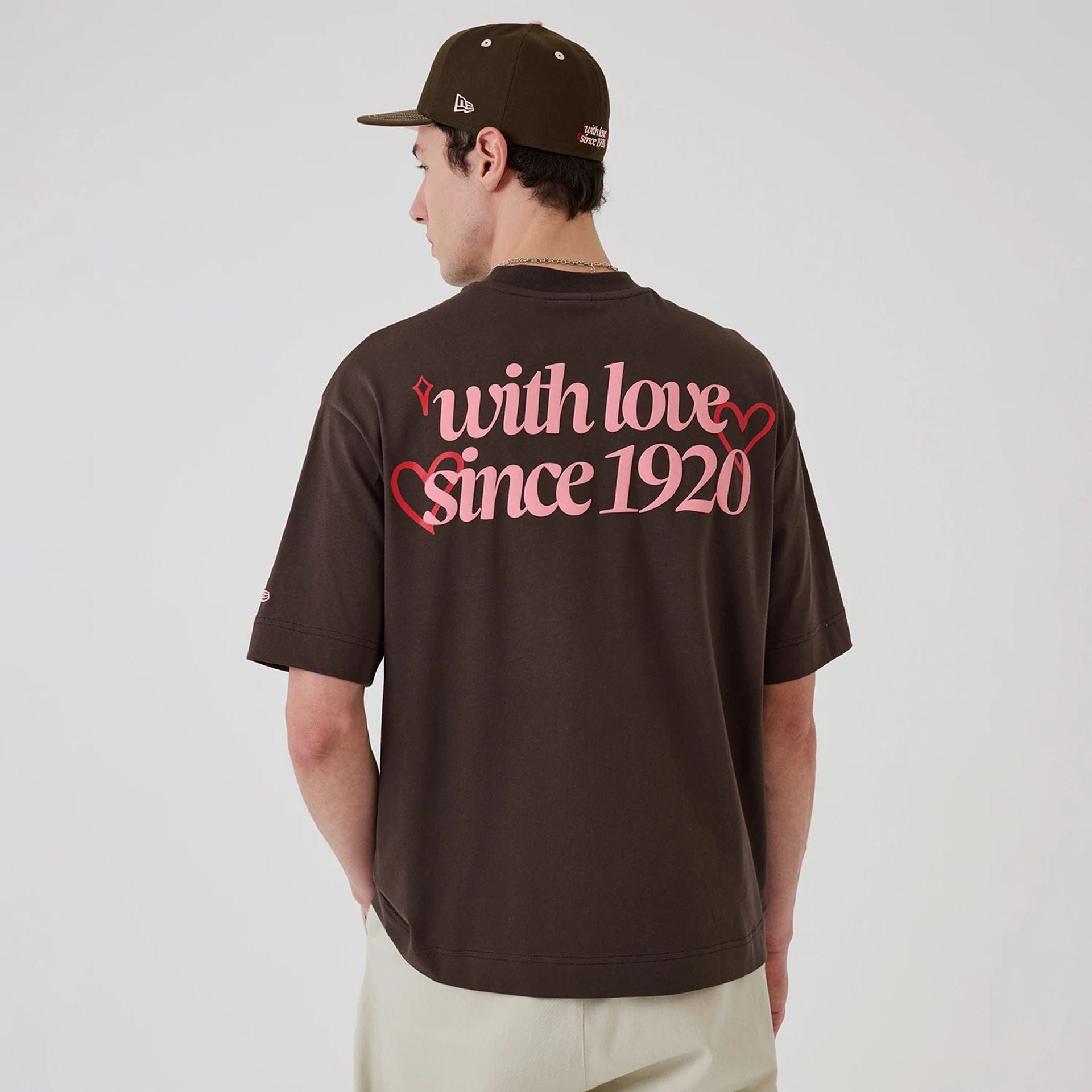 The model is wearing this New Era Love Graphic T-Shirt in dark brown. 2