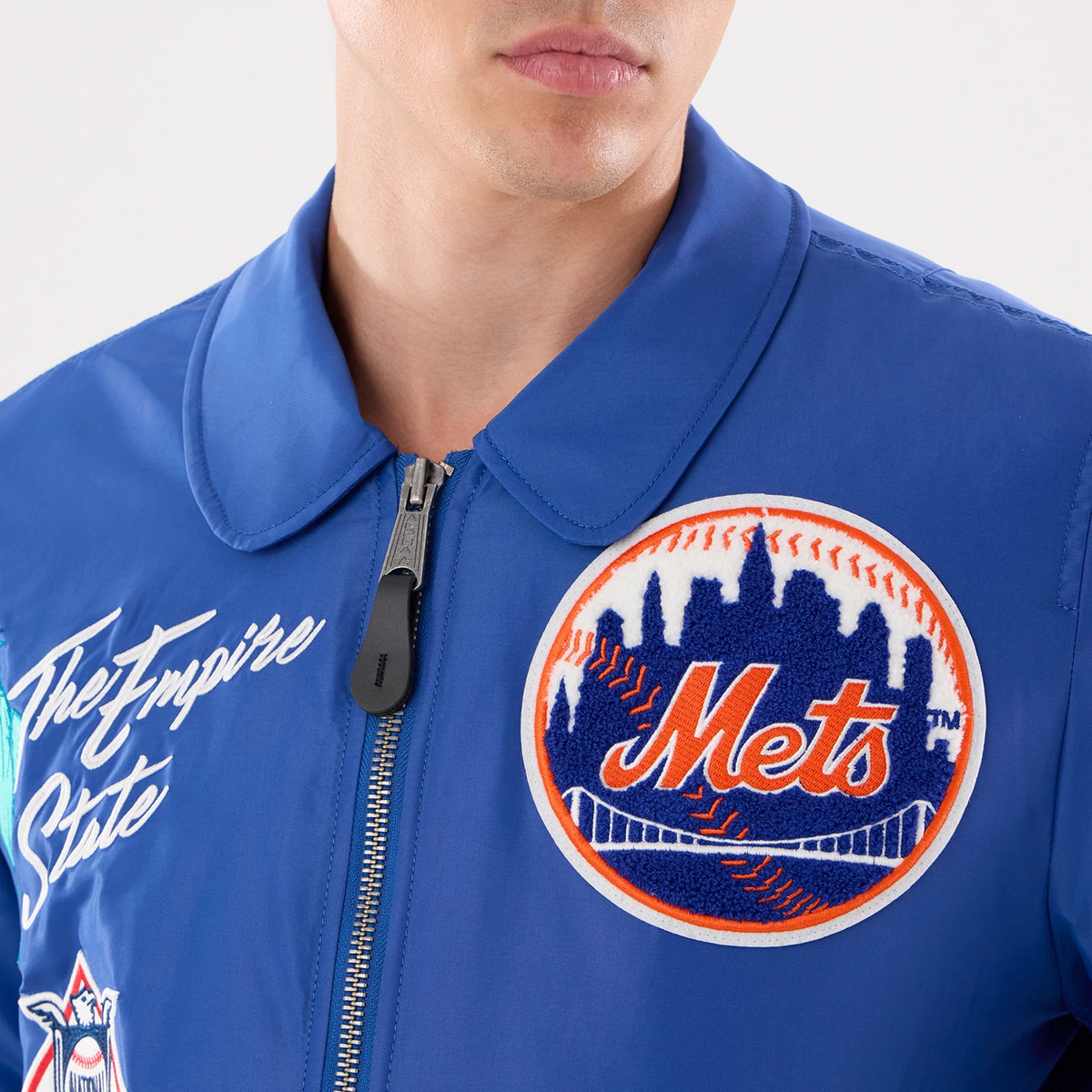 The model is wearing this MLB X Alpha New York Mets Jacket in Blue. 4