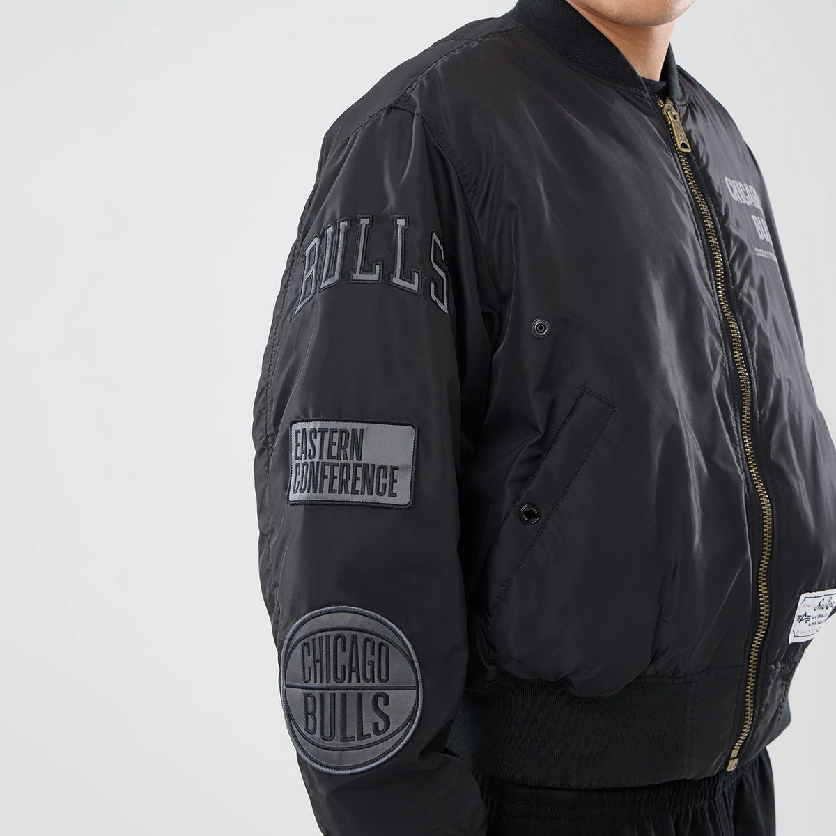 The model is wearing this NBA X Alpha Chicago Bulls Bomber Jacket & Tactical Vest in black. 4