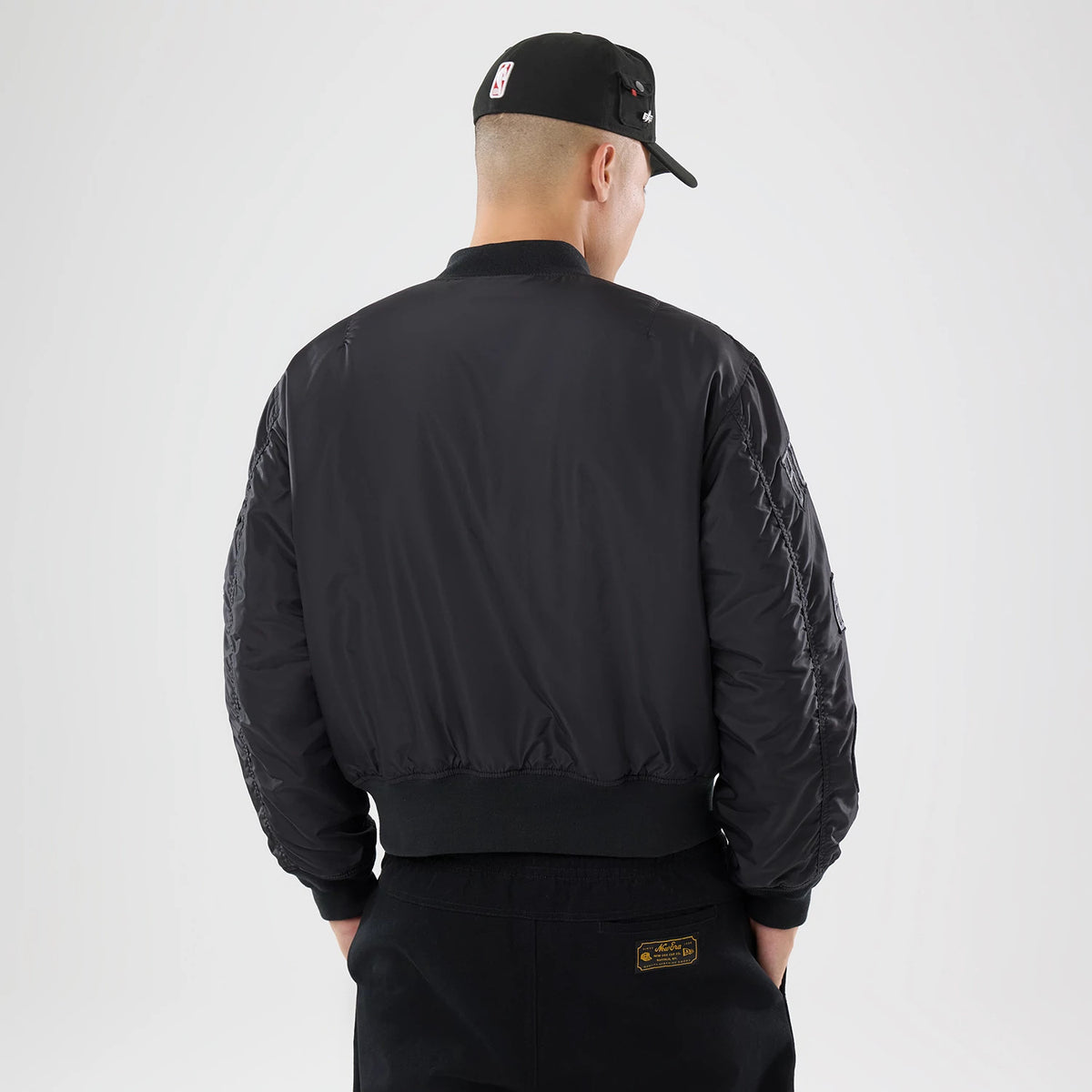The model is wearing this NBA X Alpha Chicago Bulls Bomber Jacket & Tactical Vest in black. 2