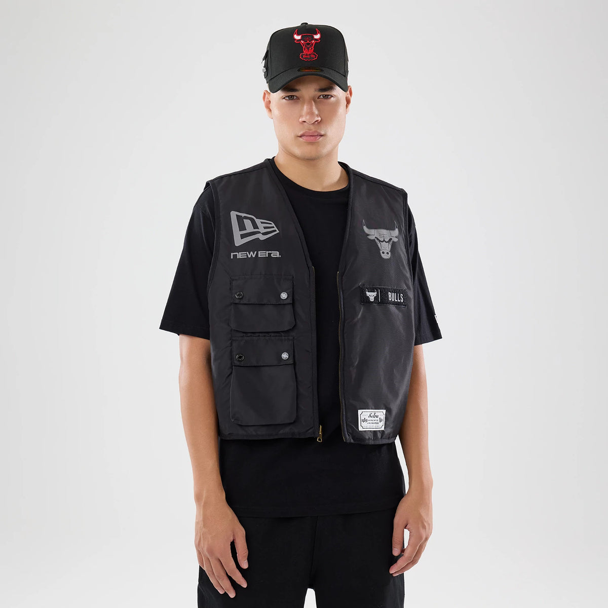 The model is wearing this NBA X Alpha Chicago Bulls Bomber Jacket & Tactical Vest in black. 2
