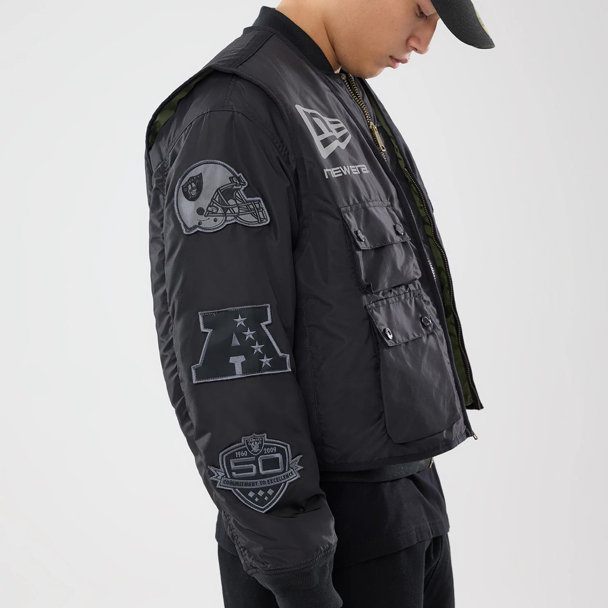 The model is wearing this NFL X Alpha Las Vegas Raiders Bomber Jacket & Tactical Vest in black. 3