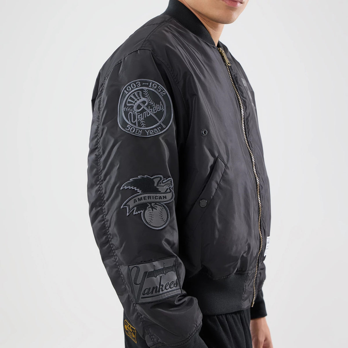 The model is wearing this MLB X Alpha New York Yankees Bomber Jacket & Tactical Vest in black. 4
