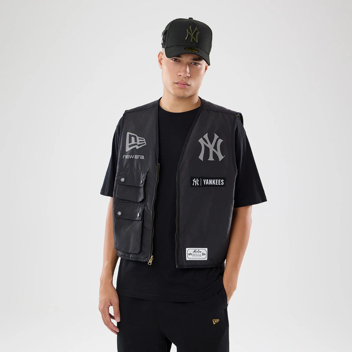 The model is wearing this MLB X Alpha New York Yankees Bomber Jacket & Tactical Vest in black. 2