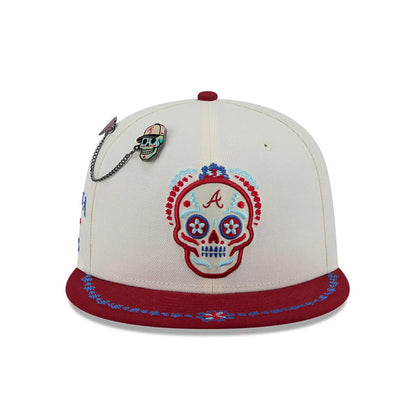 Pictured is this MLB Day Of The Dead Atlanta Braves 59FIFTY Fitted cap in light beige & dark red. 3