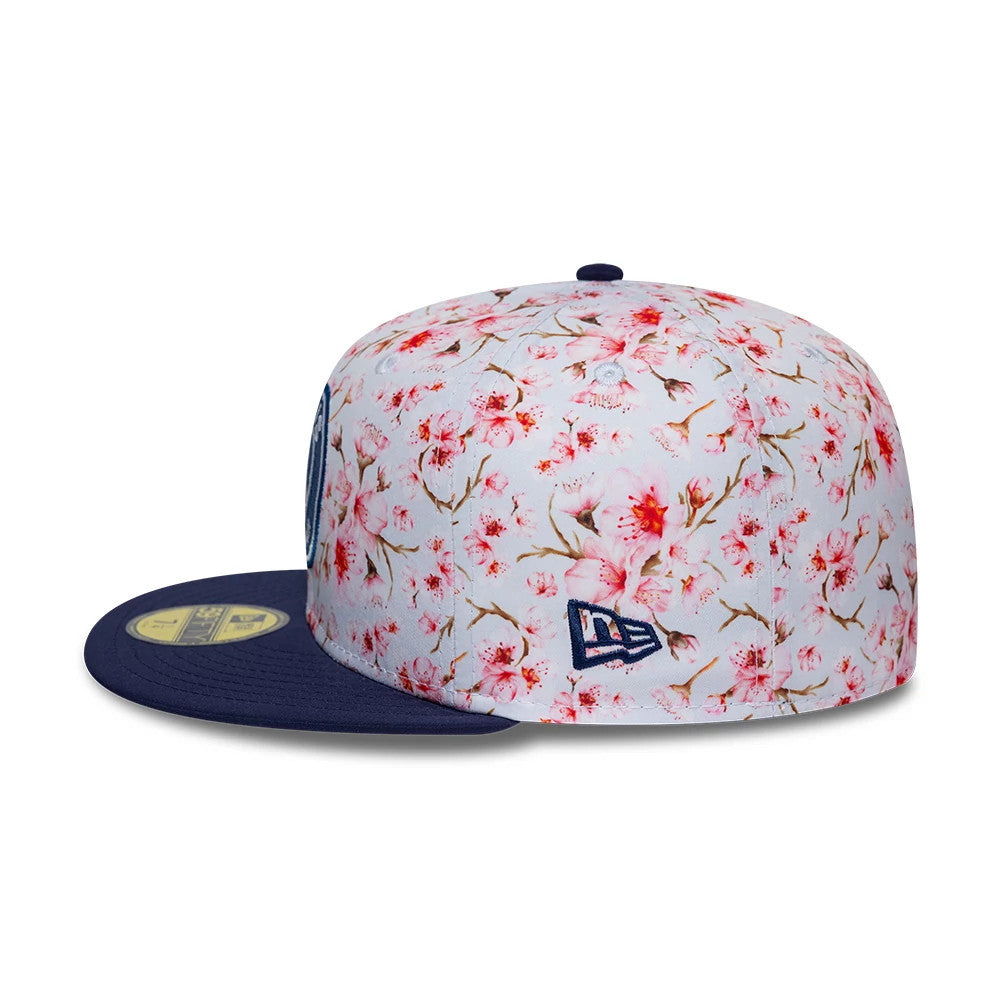 Paris Saint-Germain Cherry Blossom Navy New Era 59FIFTY Fitted Cap, side view showing the floral cherry blossom pattern on the crown, a navy flat visor with a gold 59FIFTY size sticker, and the embroidered New Era flag logo on the left side.