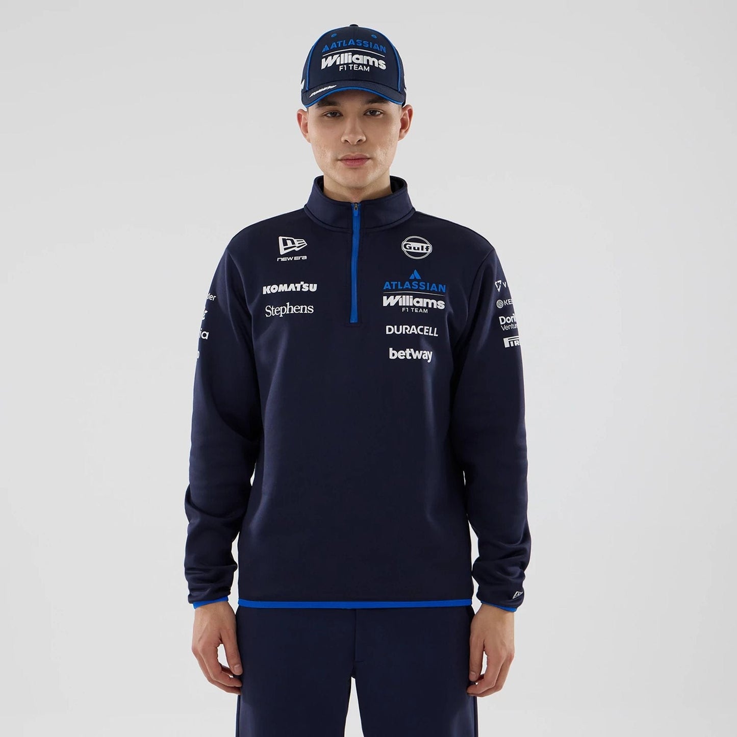 The model is wearing this Atlassian Williams F1 Team Mid Layer 1/4 Zip Long Sleeve T-Shirt in navy. 1