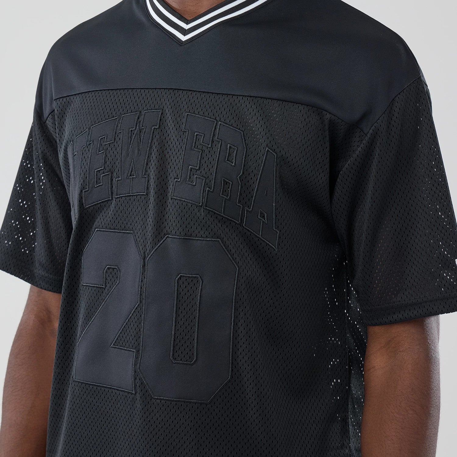 The model is wearing this New Era Mesh Oversized T-Shirt in black. 3