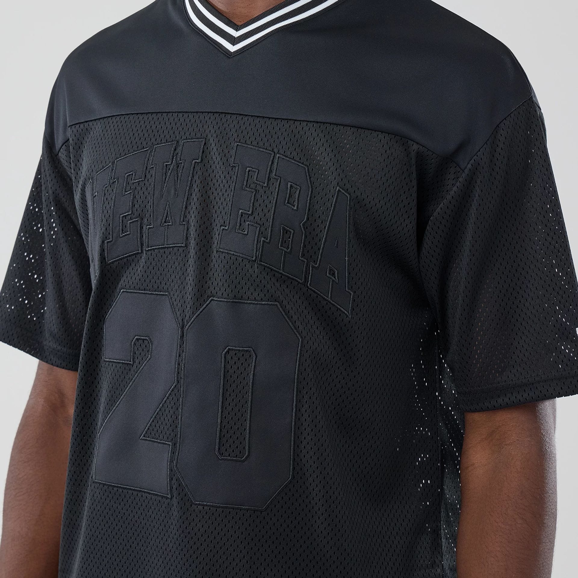 The model is wearing this New Era Mesh Oversized T-Shirt in black. 3
