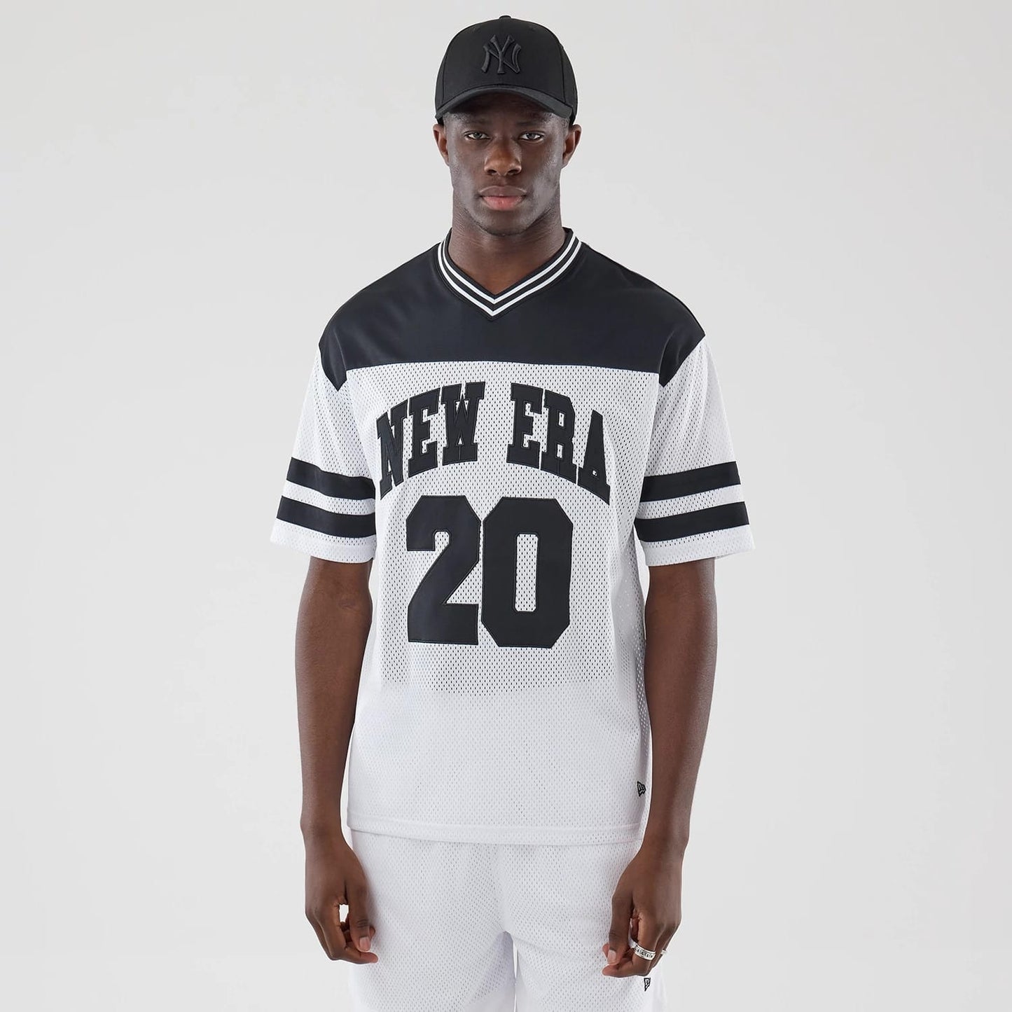 The model is wearing this New Era Mesh Oversized T-Shirt in white. 1