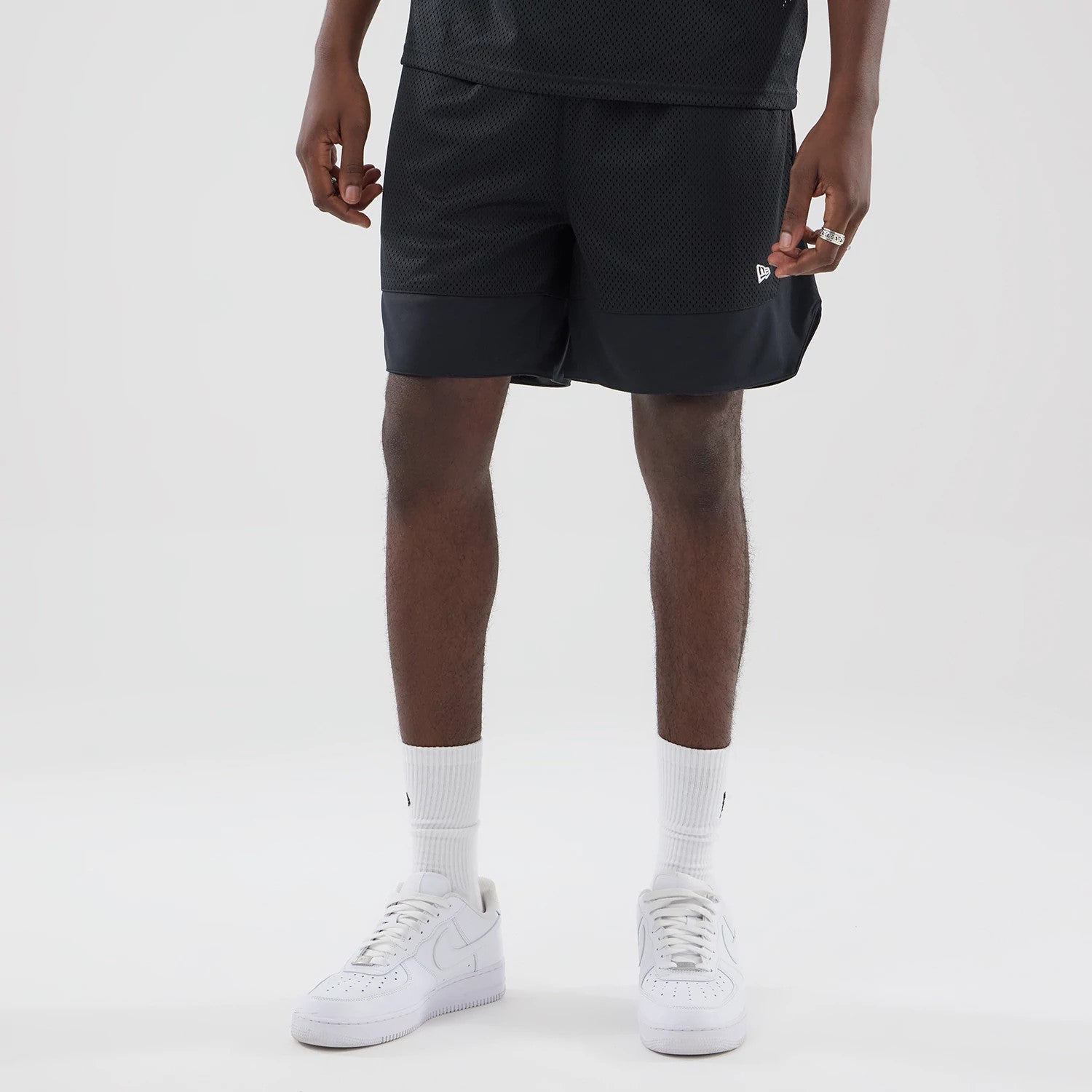 The model is wearing this New Era Mesh Stripe Oversized Shorts in black. 3