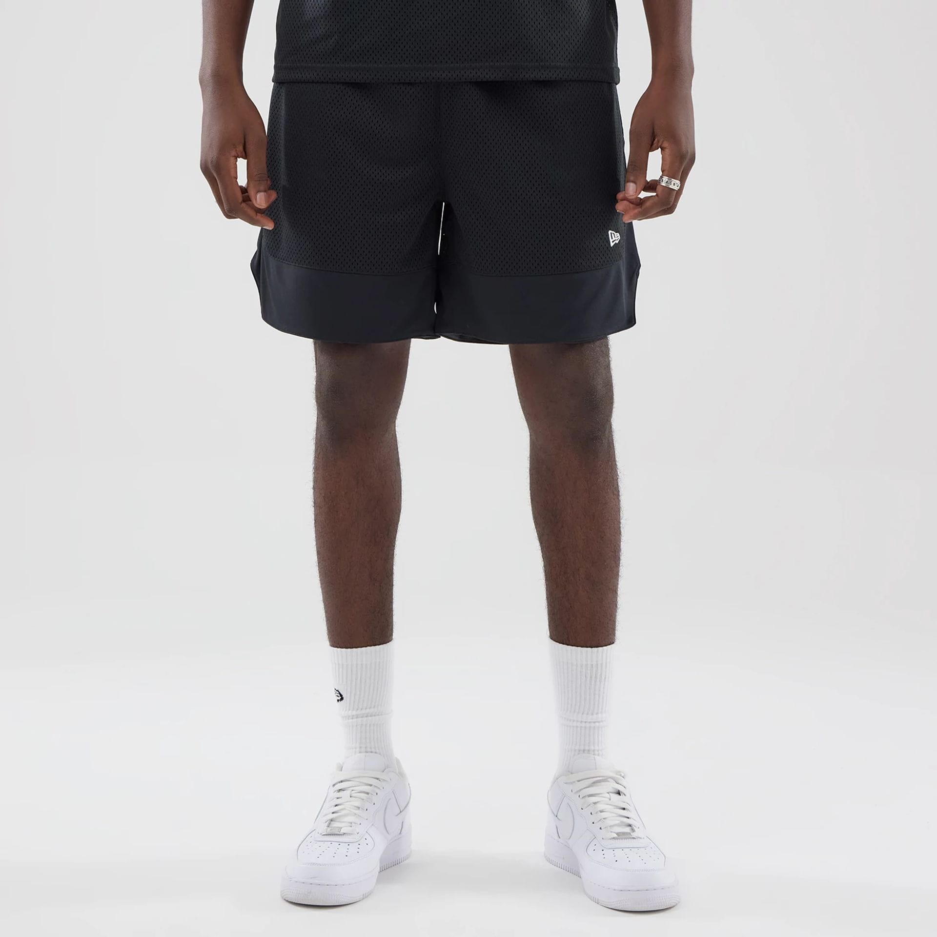 The model is wearing this New Era Mesh Oversized Shorts in black. 1