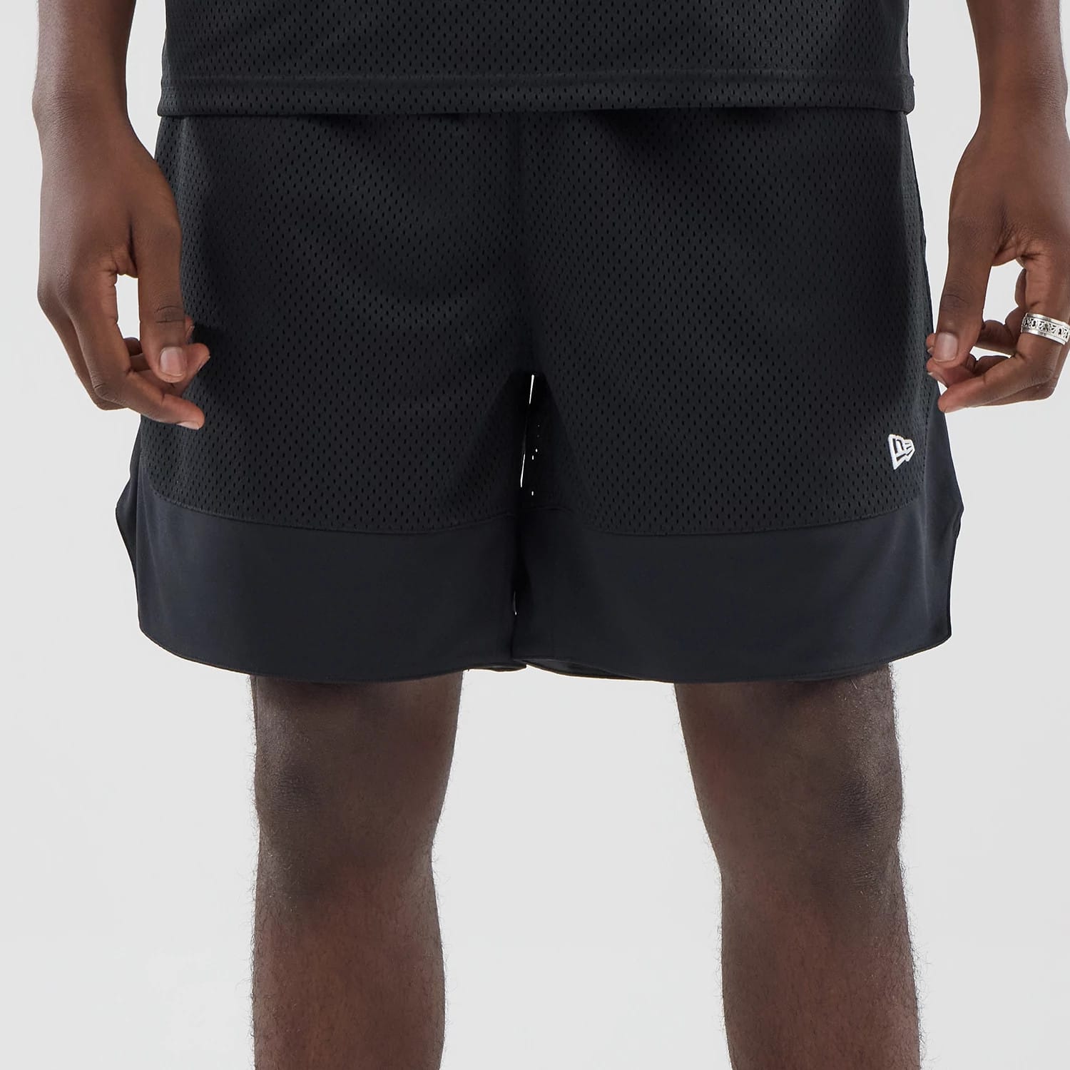 The model is wearing this New Era Mesh Stripe Oversized Shorts in black. 6