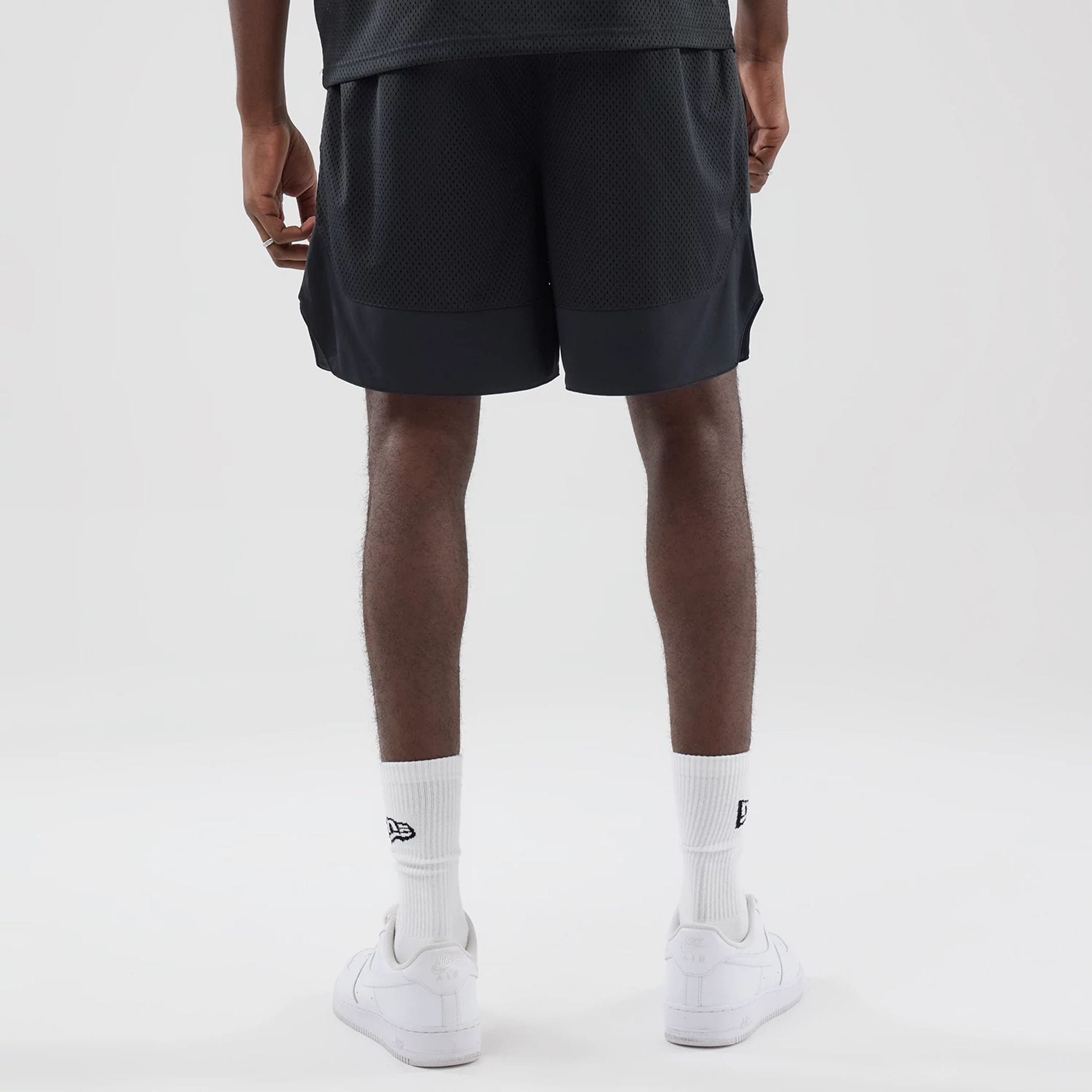 The model is wearing this New Era Mesh Oversized Shorts in black. 2