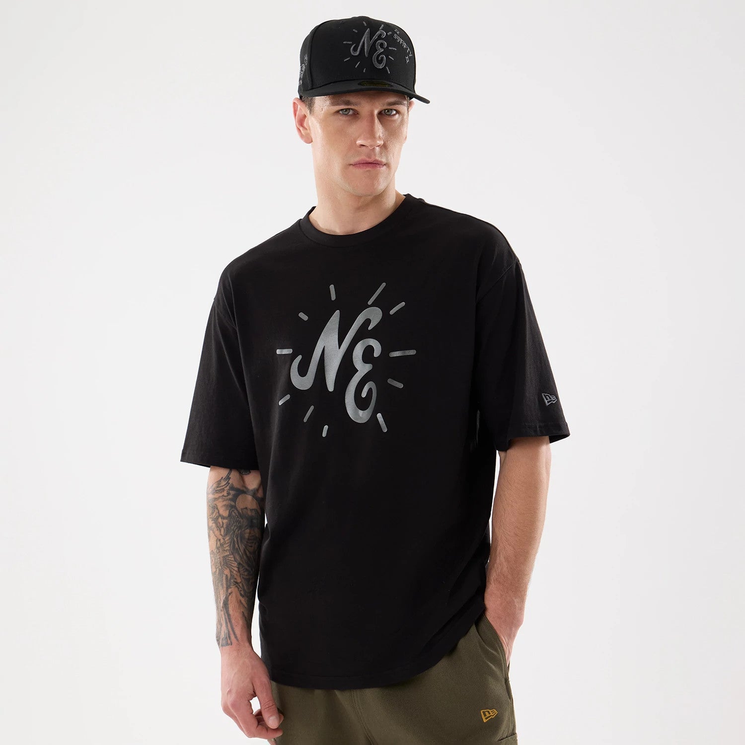 The model is wearing this New Era 59FIFTY Day Graphic T-Shirt in black. 1