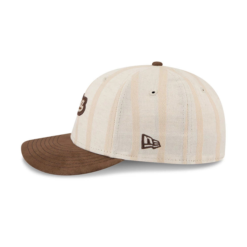 New Era 59FIFTY Day Open Beige Low Profile 59FIFTY Fitted Cap, side view showing the brown embroidered New Era flag logo on the left side, with a beige crown featuring vertical stripes and a brown flat visor.