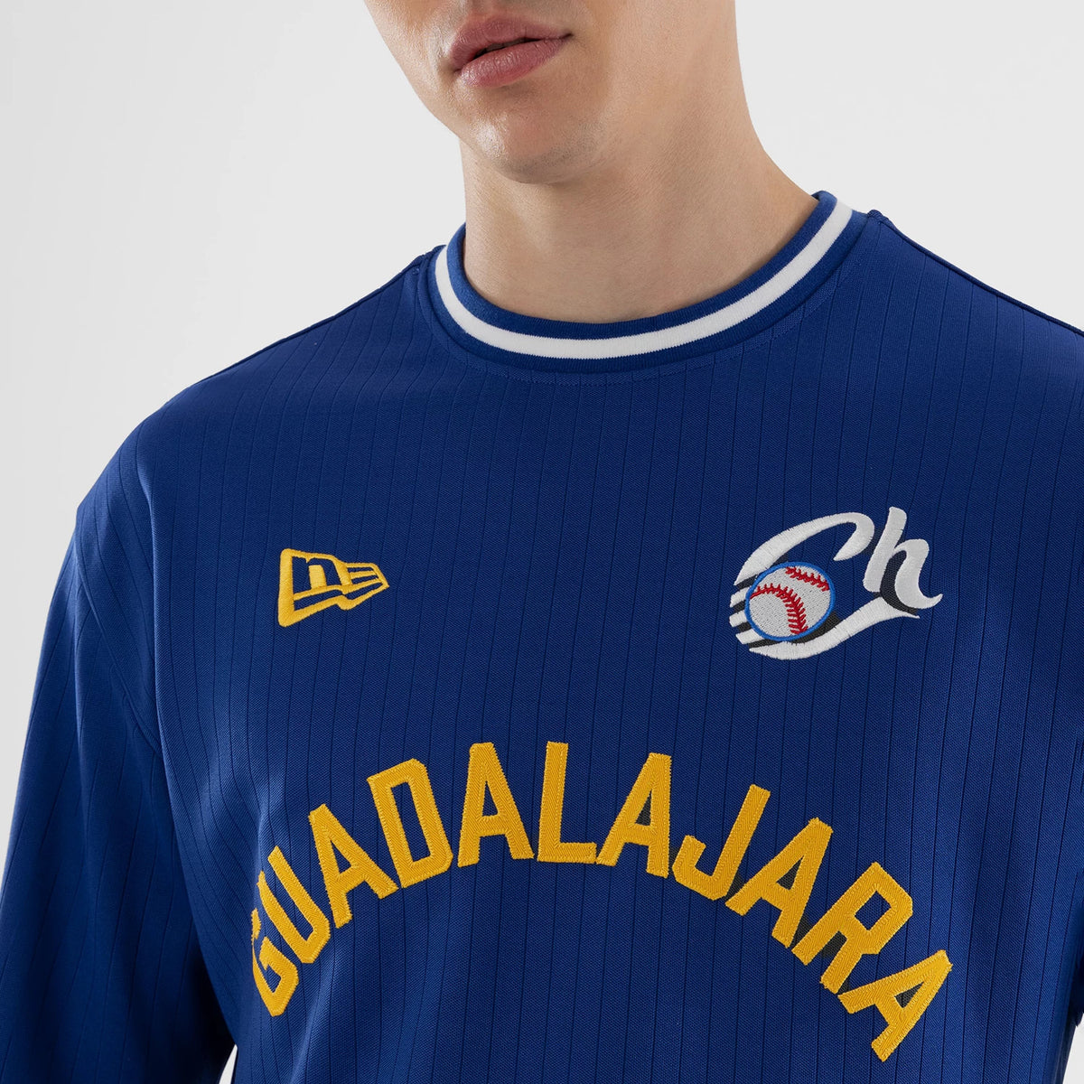 New Era Charros De Jalisco LMB Blue Oversized T-Shirt, front view showing an embroidered Guadalajara in yellow across the chest, a yellow embroidered New Era logo on the upper chest, and a white embroidered baseball motif with Ch on the shoulder.