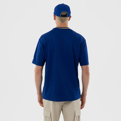 New Era Kansas City Royals MLB Blue Oversized T-Shirt, back view on a model with a matching blue cap, showing a plain blue back with a ribbed texture, short sleeves and contrast colour around the ribbed neckline.