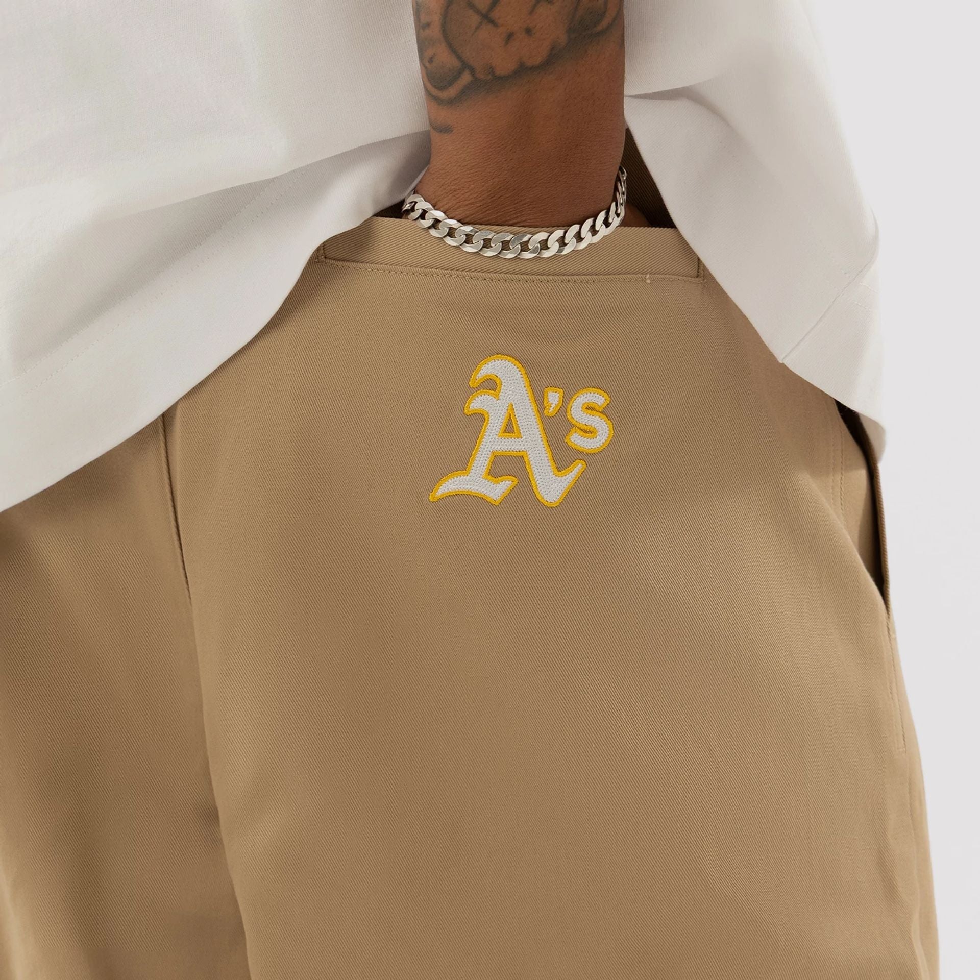 The model is wearing this MLB Athletics Chino Trousers in light beige. 3