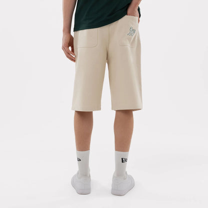 The model is wearing this MLB Jort Athletics Oversized Shorts in Cream. 2