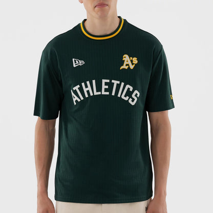 New Era Athletics MLB Dark Green Oversized T-Shirt, front view on a model showing the embroidered A’s logo on the left chest, a large white Athletics lettering across the centre, and a New Era logo on the right shoulder.