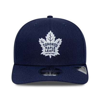 Toronto Maple Leafs NHL Team Navy New Era 9SEVENTY Stretch Snap Adjustable Cap, front view showing the raised embroidered white leaf logo on the structured navy crown, with a curved visor featuring a 9SEVENTY size sticker on the visor.