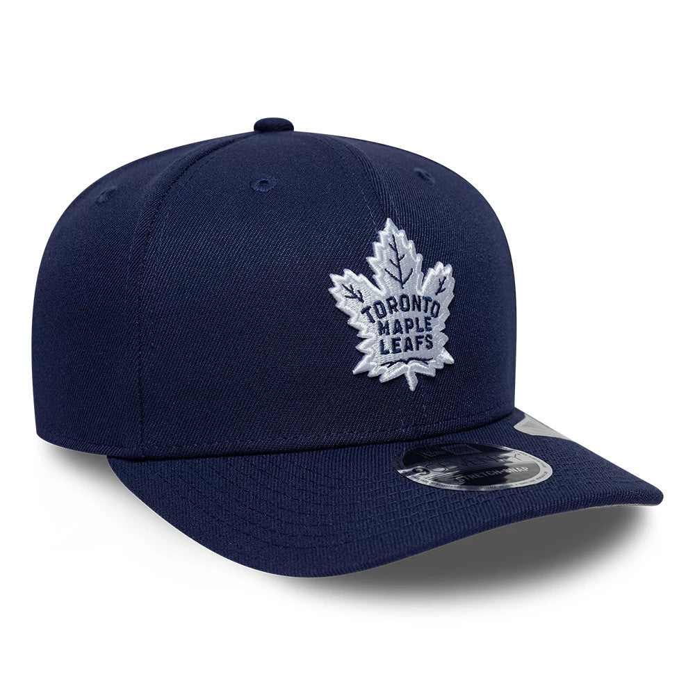 Toronto Maple Leafs NHL Team Navy New Era 9SEVENTY Stretch Snap Adjustable Cap, front view showing the white embroidered maple leaf logo on the navy front panel, navy curved visor, and 9SEVENTY size sticker on the visor.