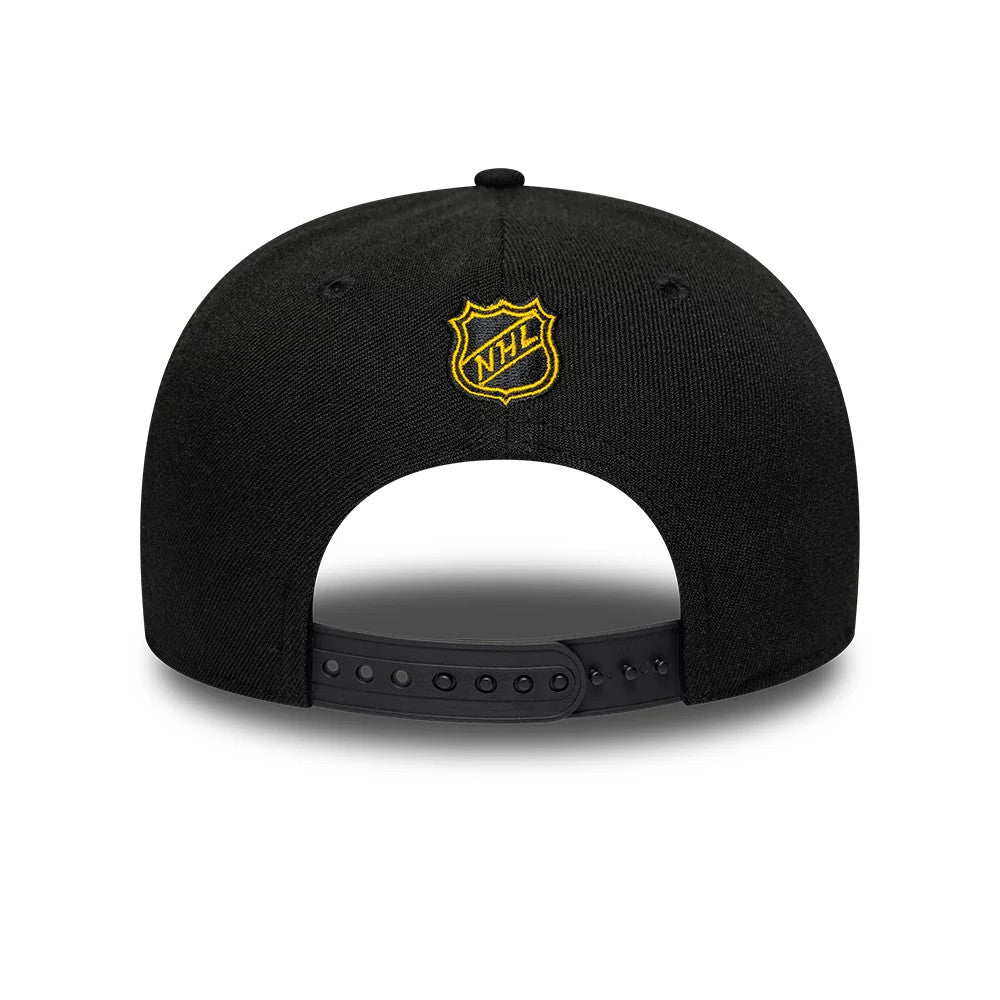Boston Bruins NHL Team Black New Era 9SEVENTY Stretch Snap Adjustable Cap, rear view showing a yellow and white embroidered NHL logo shield centred on the back panels, with a black adjustable strap and the black structured crown.