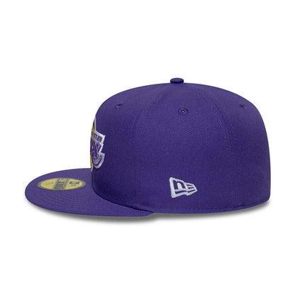 LA Lakers NBA Hardwood Classic Purple New Era 59FIFTY Fitted Cap, side view showing the white embroidered New Era flag logo on the left side of the structured purple crown, with a flat purple visor and a gold 59FIFTY size sticker.