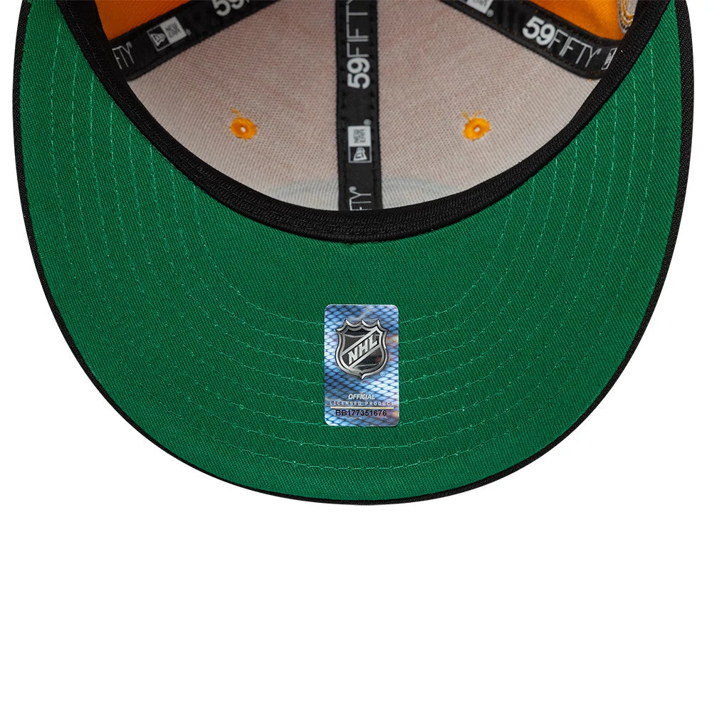 Boston Bruins NHL Champions Orange & Black New Era 59FIFTY Fitted Cap, inside view showing the black brand taping on orange fabric, green undervisor with an NHL sticker at the centre, and orange eyelets on the crown.