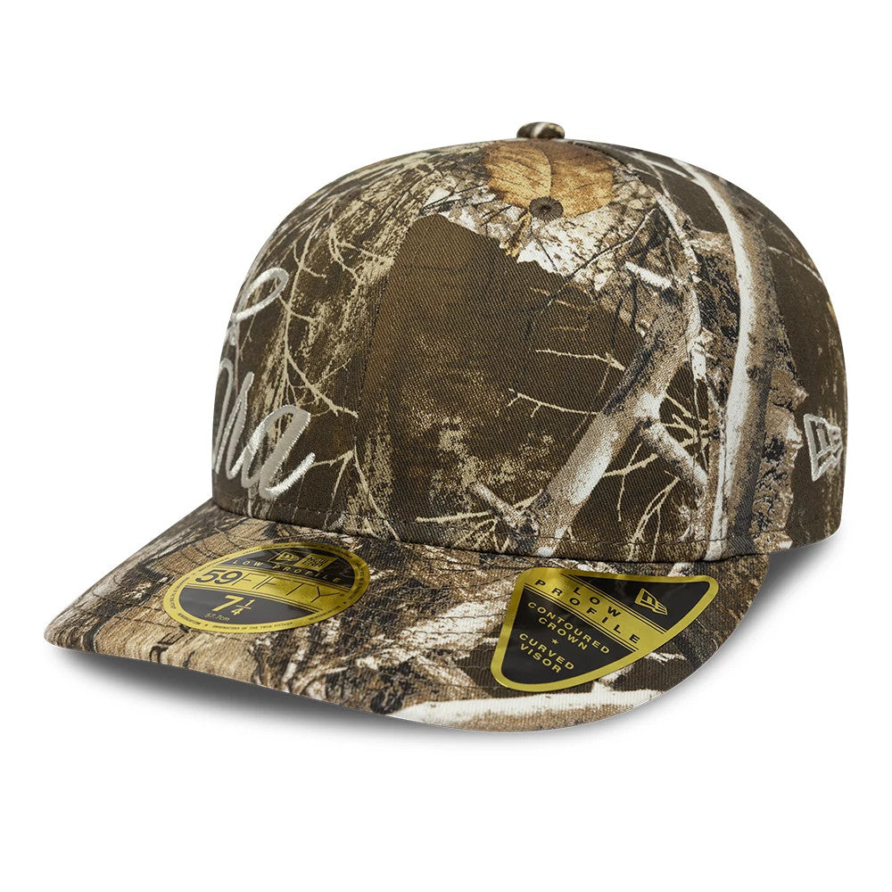 New Era Side Script Realtree Camo Low Profile 59FIFTY Fitted Cap, three-quarter view showing a white embroidered script logo on the side, camo pattern across the structured crown and visor, and a gold 59FIFTY size sticker on the camo visor.